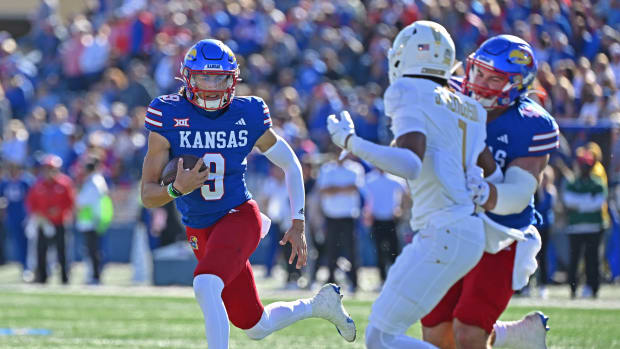 Oct 7, 2023; Lawrence, Kansas, USA; Kansas Jayhawks quarterback Jason Bean (9) runs to the outside against UCF Knights defensive back Ja'Cari Henderson (1) during the first half at David Booth Kansas Memorial Stadium. Mandatory Credit: Peter Aiken-USA TODAY Sports  